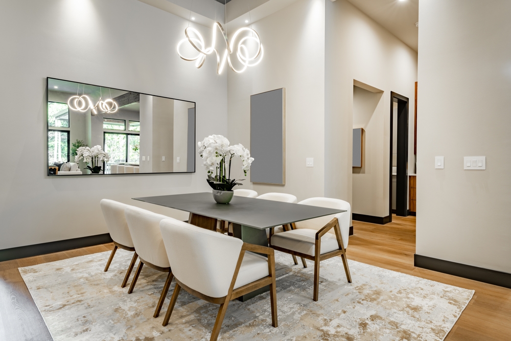 A dining room with white chairs and a table