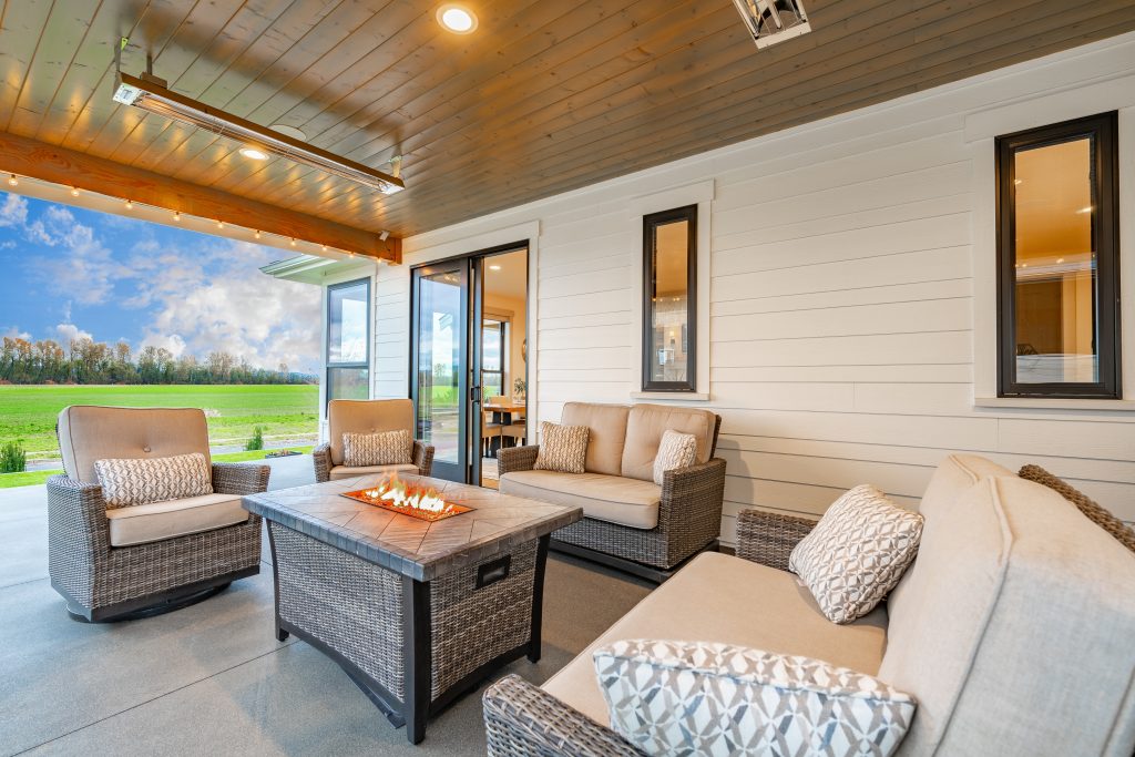 A patio with couches and fire pit in the middle of it.